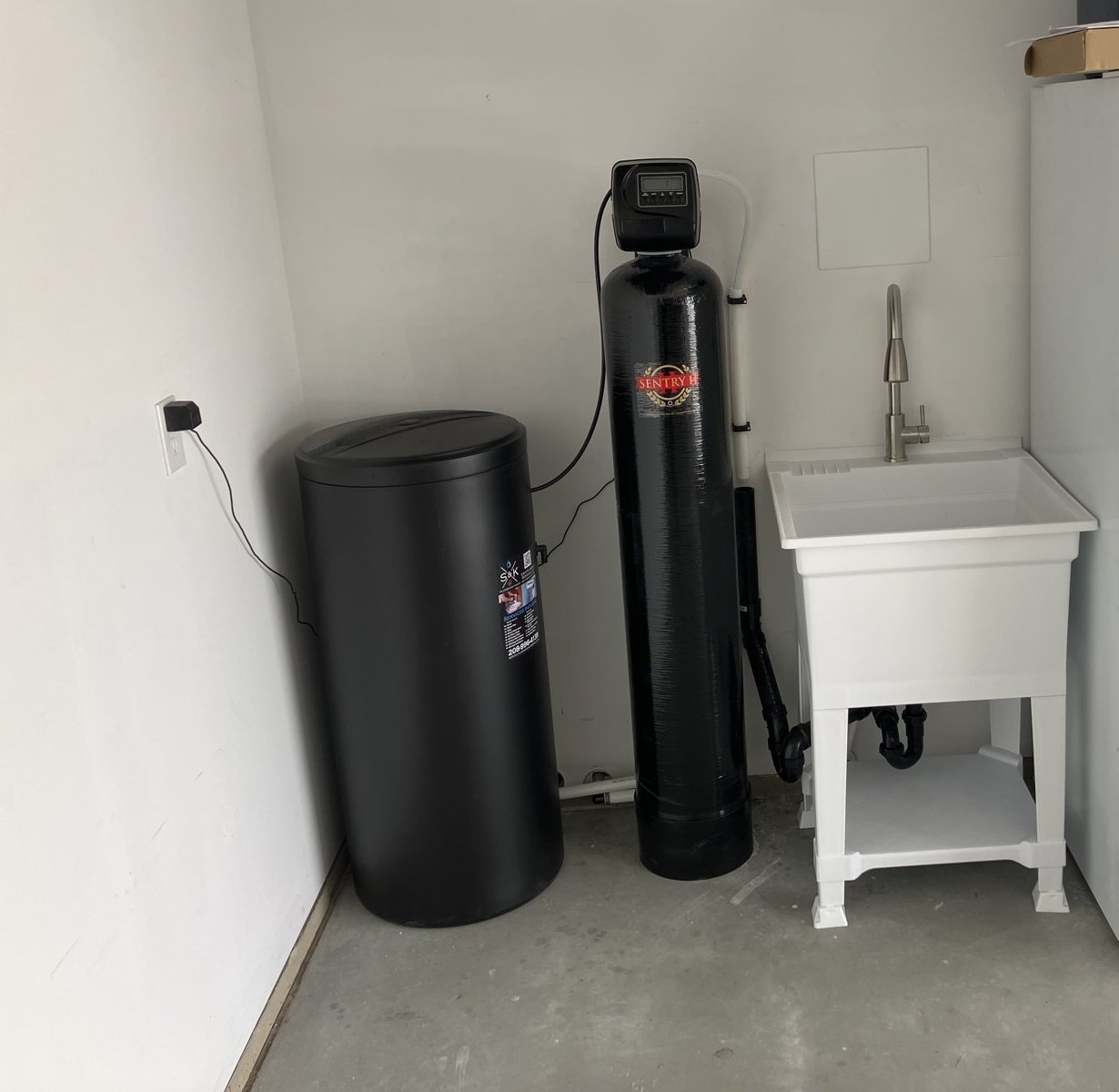 48K Sentry II water softener and brine tank installed next to a new utility sink in a Meridian garage
