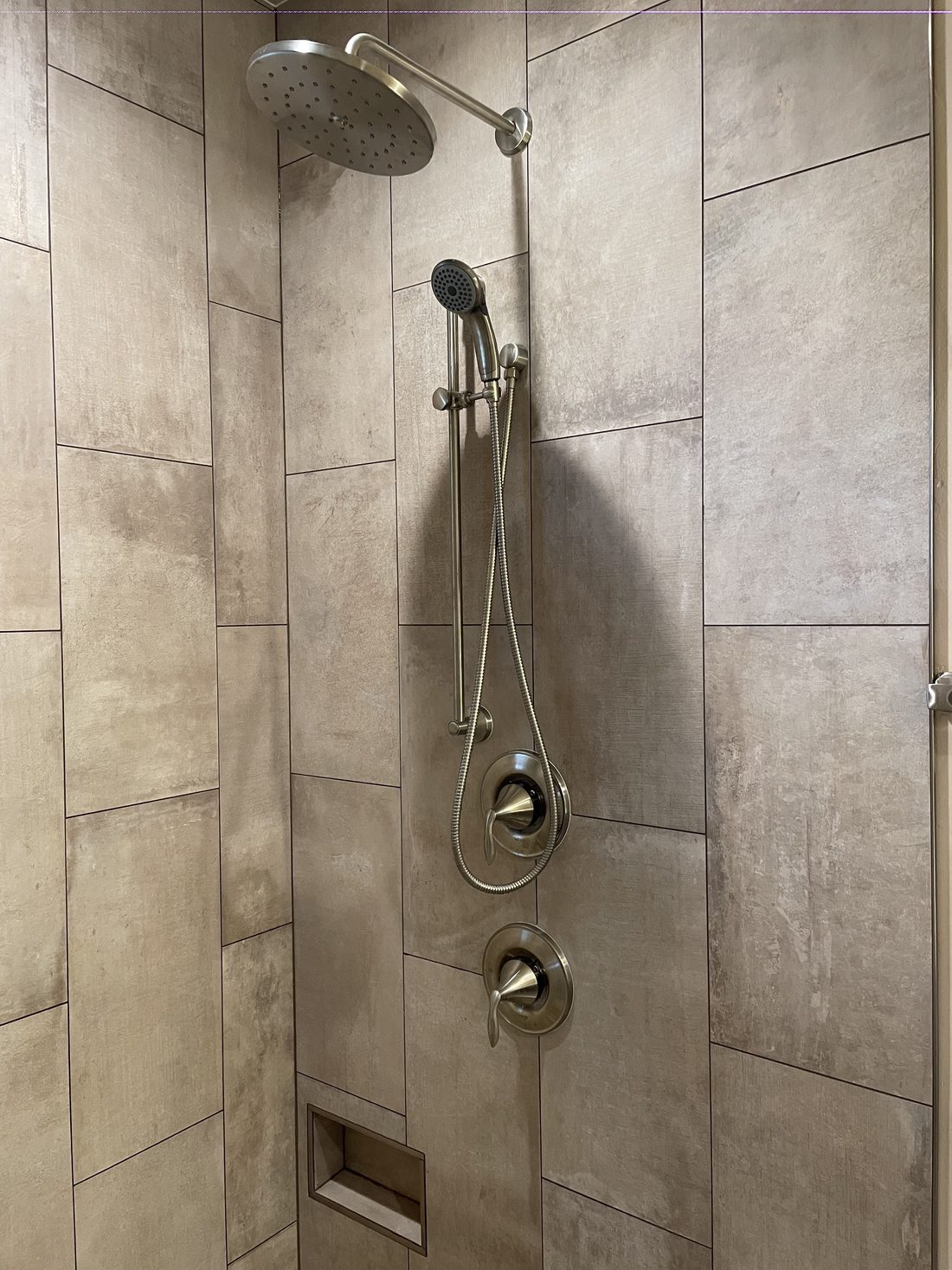 Brushed nickel shower trim and handheld shower installed by S&K at a remodel in McCall, Idaho